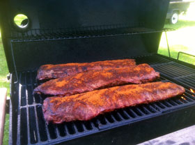 Ribs have been rubbed and smoked prior to saucing and wrapping