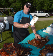 Terry preparing cooked brisket for service with a cleaver